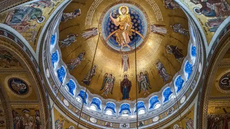 "Byzantine church ceiling adorned with mosaics, depicting a religious scene of Jesus Christ surrounded by prophets and angels."