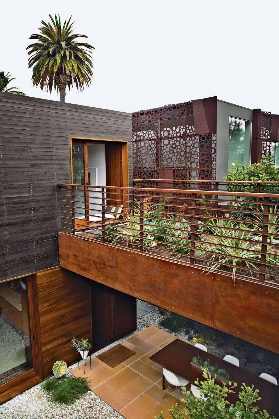 The house rises to nearly the height of the neighboring structure. The plantings on…