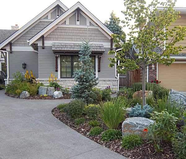 A very nicely done front yard rock garden with mulch. This mixed variety of…
