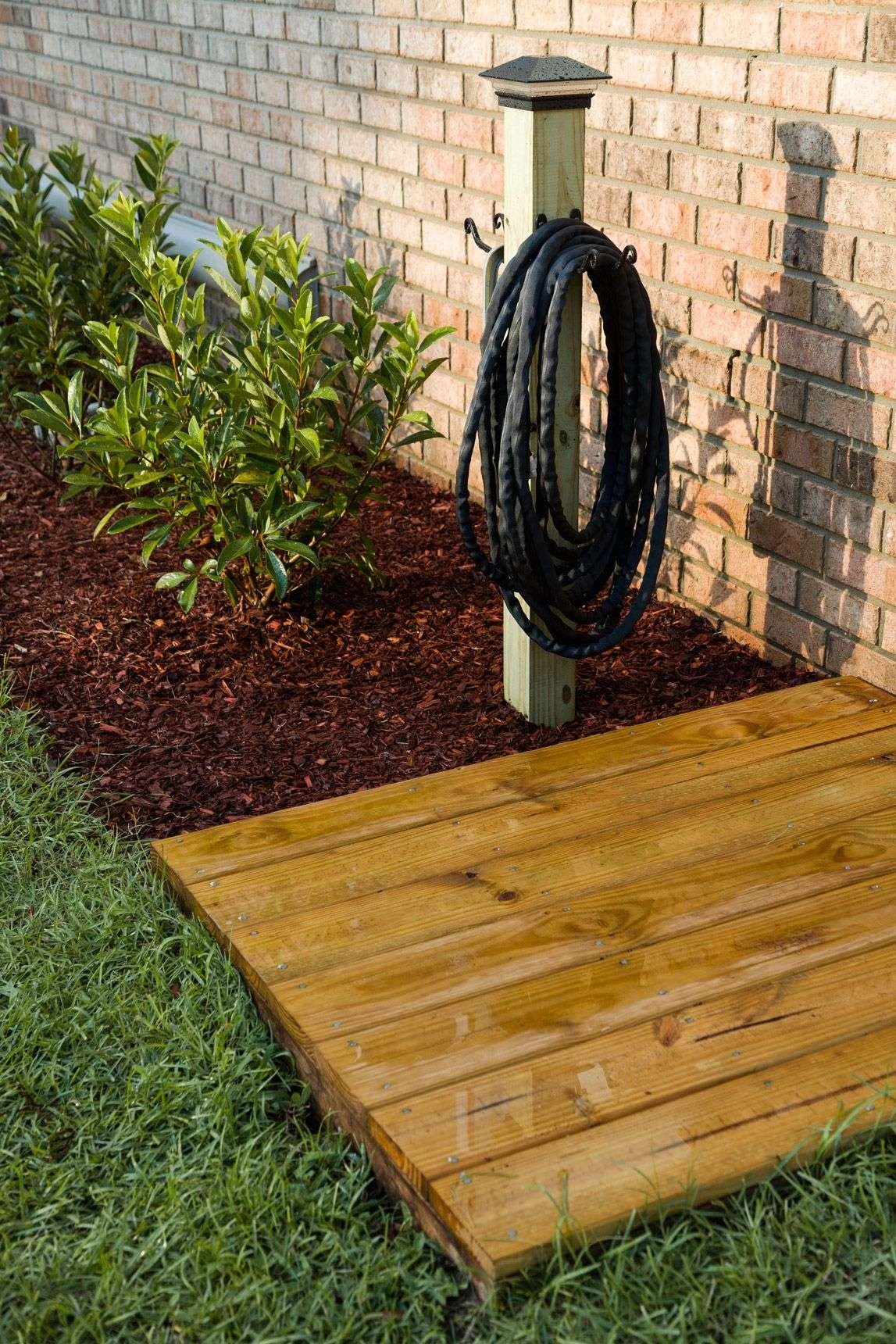 Beautiful and functional yard watering station with a floating platform deck and hose storage…