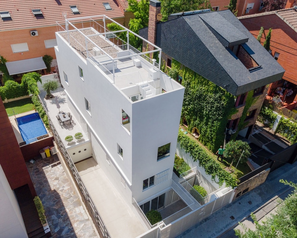 "Aerial view of a narrow house in Madrid showcasing innovative small outdoor spaces, including a garden and rooftop terrace."