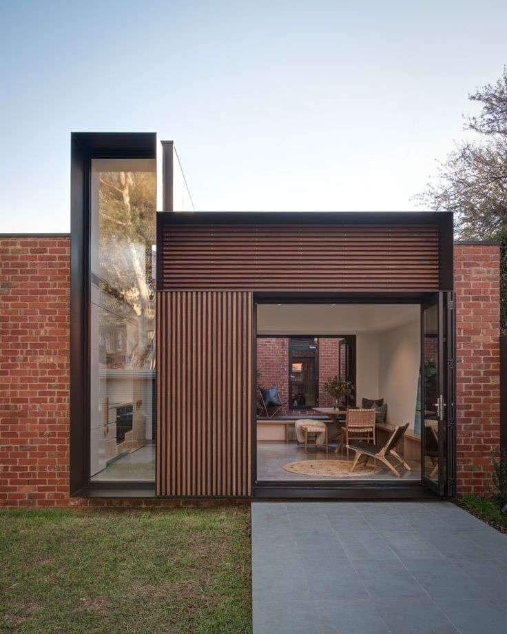 The view from the yard of this modern house addition, showcases the new brickwork…