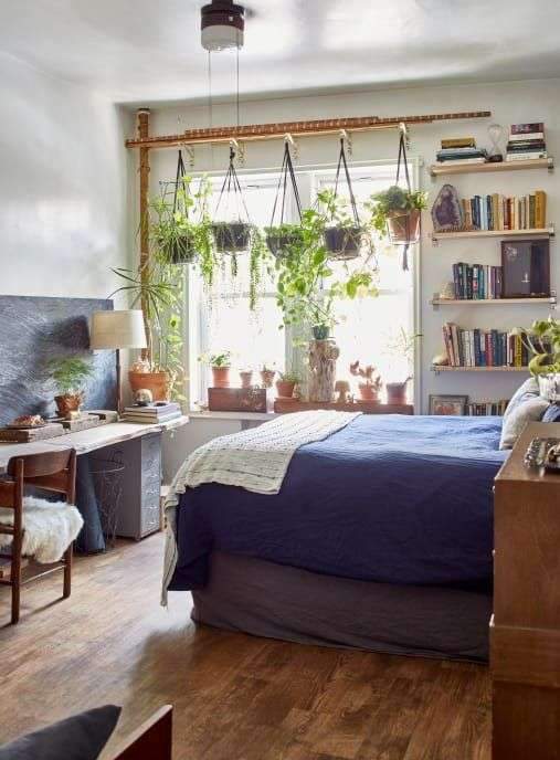 This Brooklyn rental apartment has plenty of boho charm and plants. The bedrooms are…