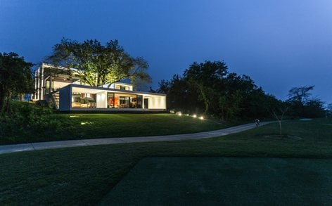 "A modern home illuminated creatively at night, showcasing innovative and stylish design"