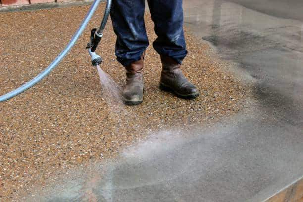 9. Exposed aggregate finish  image of a construction worker washing concrete to get an exposed aggregate finish on concrete