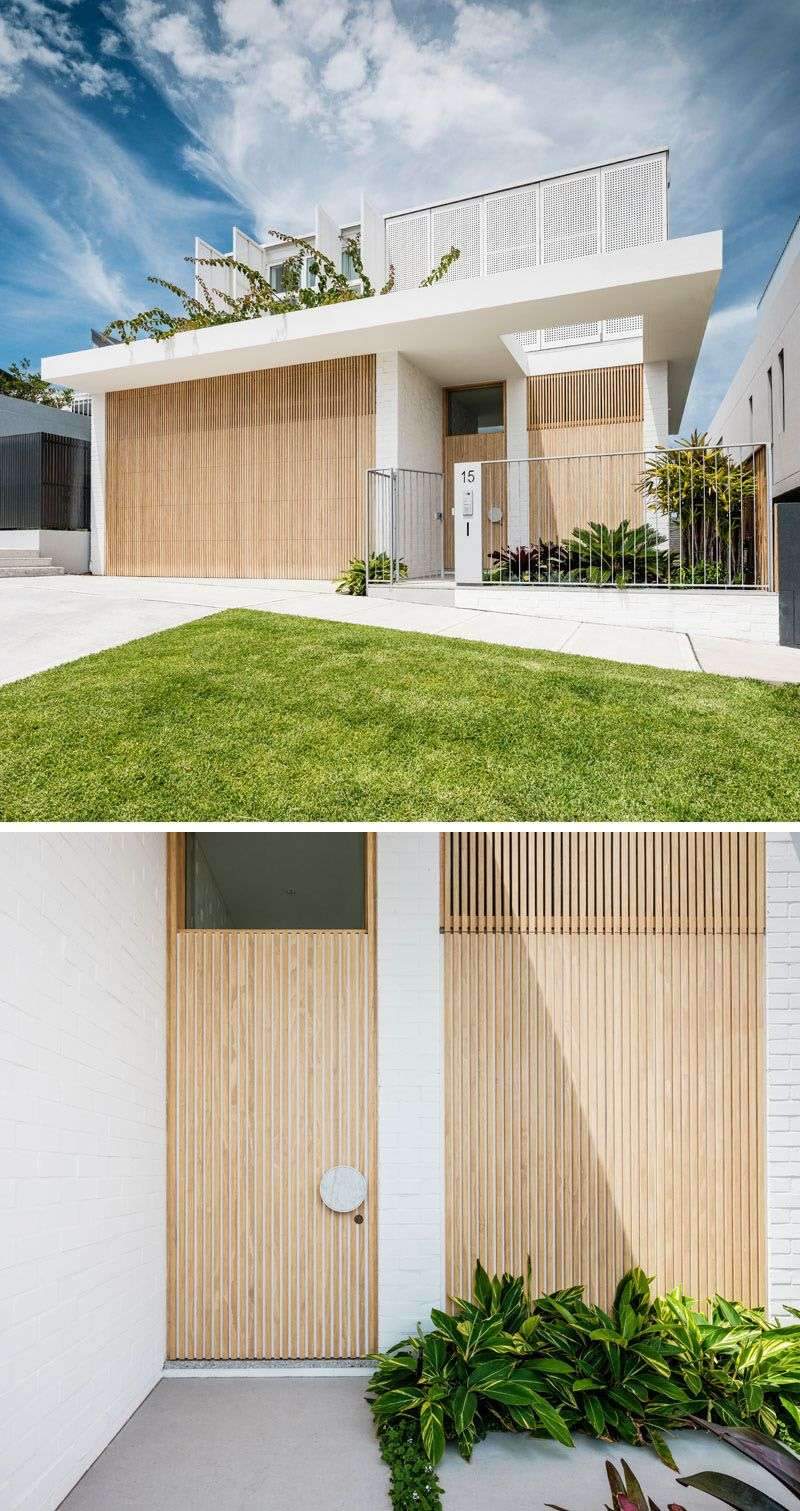 The double garage door of this modern housr is hidden in plain sight by…