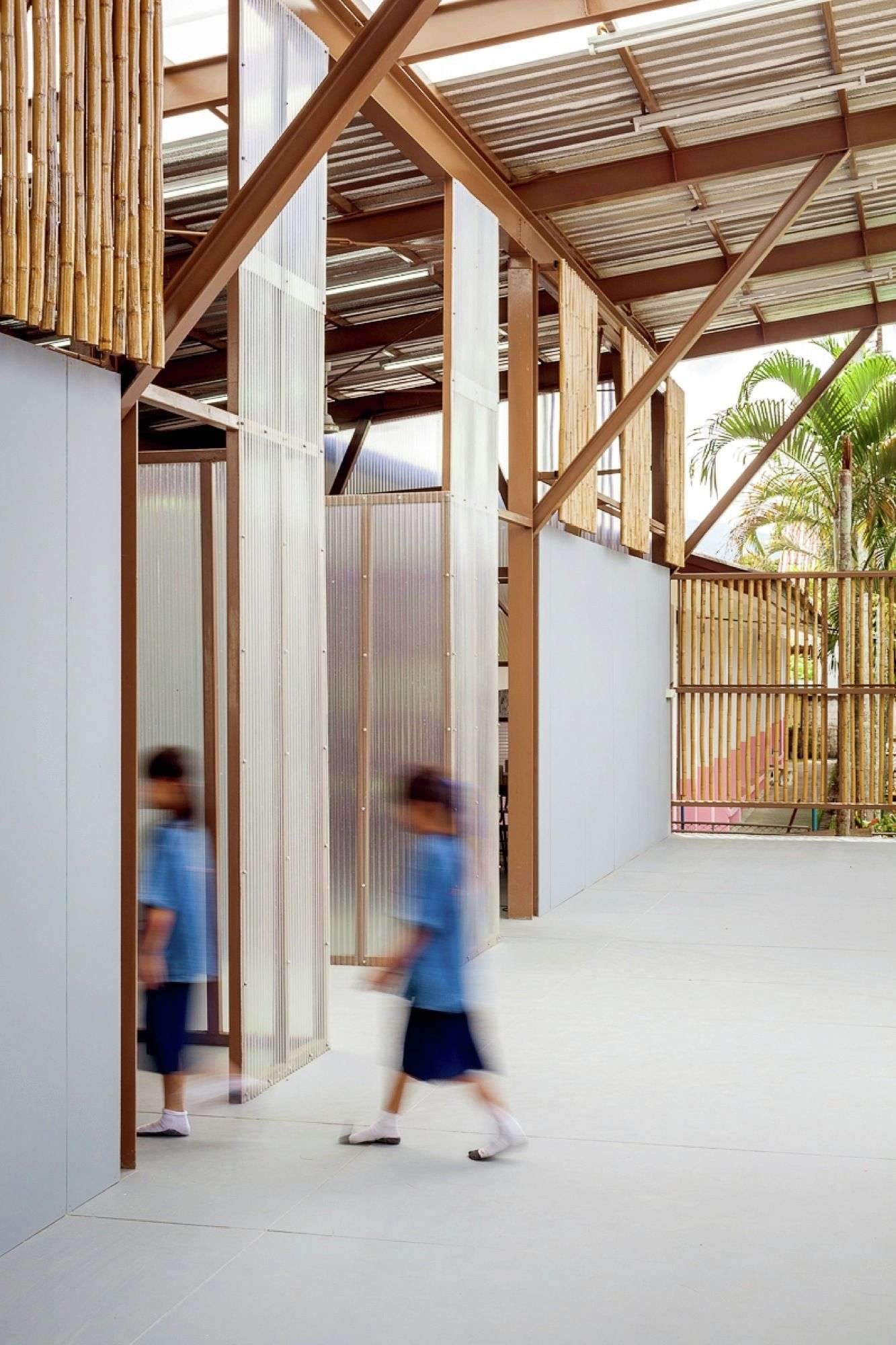 The pavilion-like Baan Nong Bua School has large roof cantilevers, is raised off the…