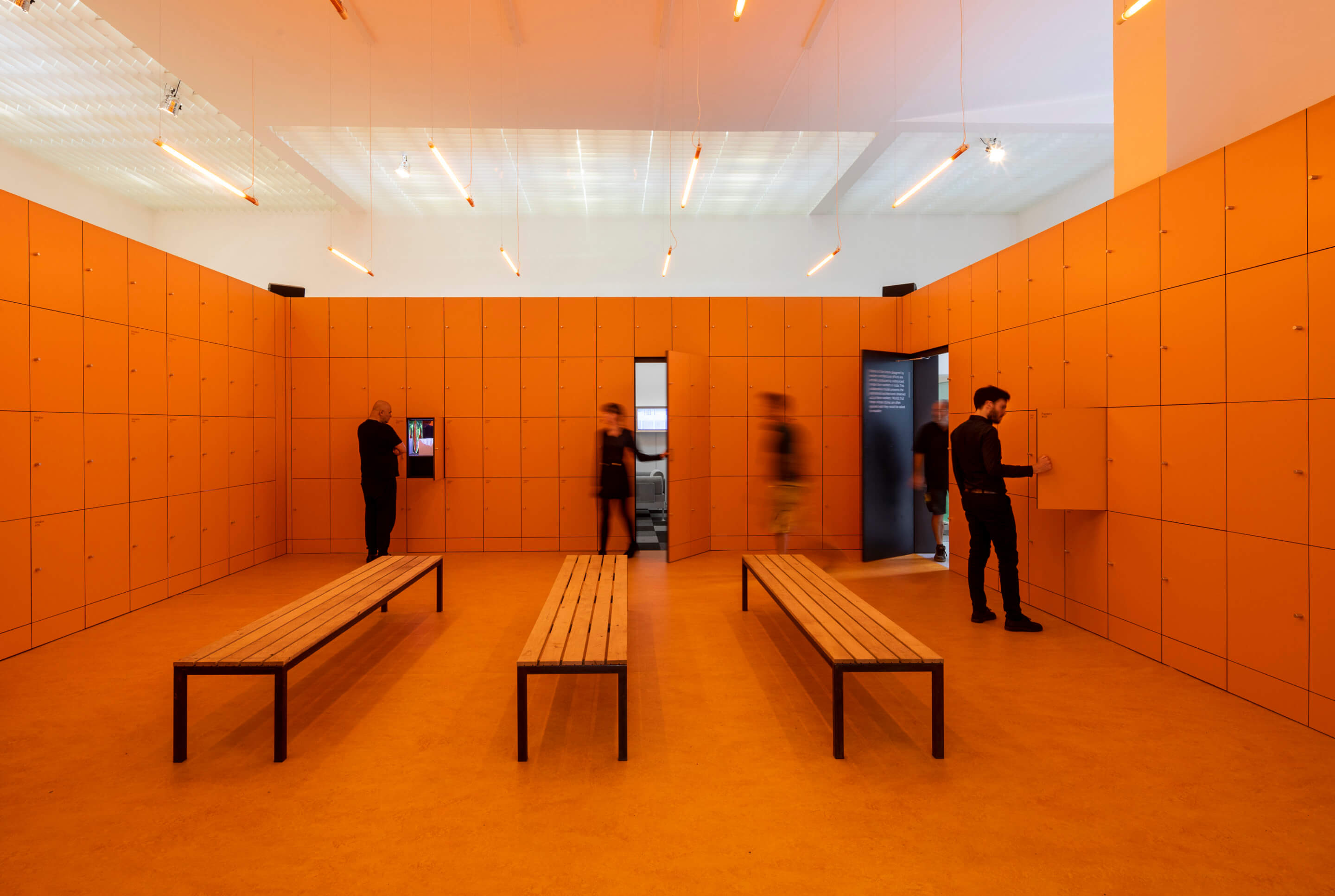 a orange-hued room with three benches