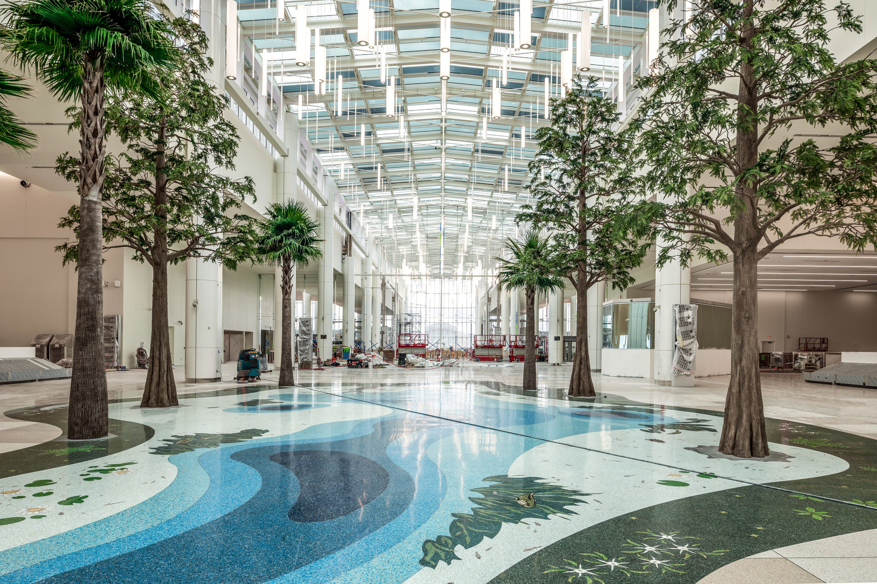 an artistic pathway flanked by trees inside an airport