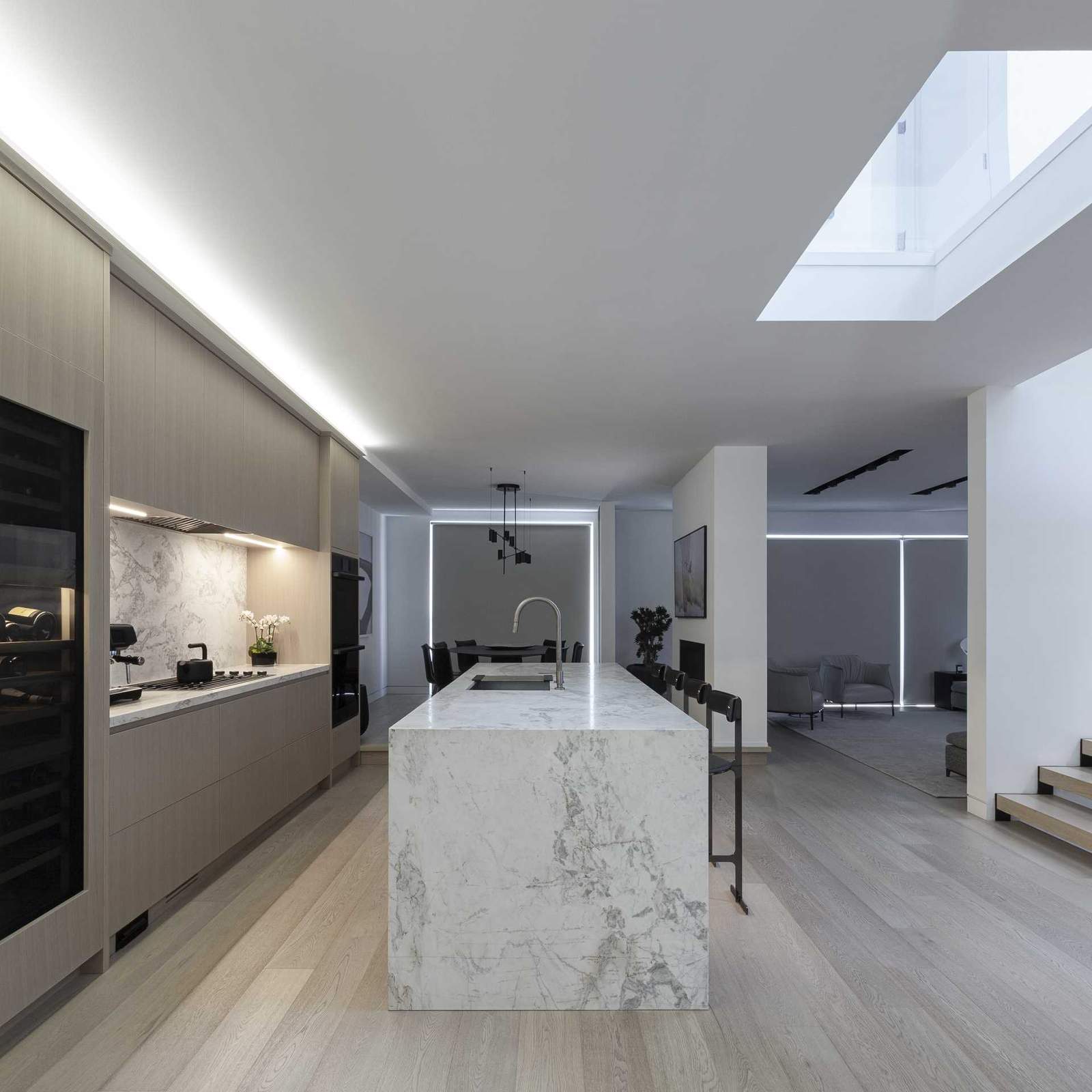 In the kitchen, a large island provides a place for seating, while the minimalist cabinets line the wall.