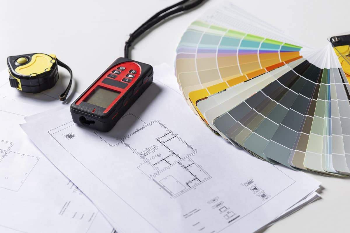Tools for the work of an interior designer on the table. How to measure distance using laser.