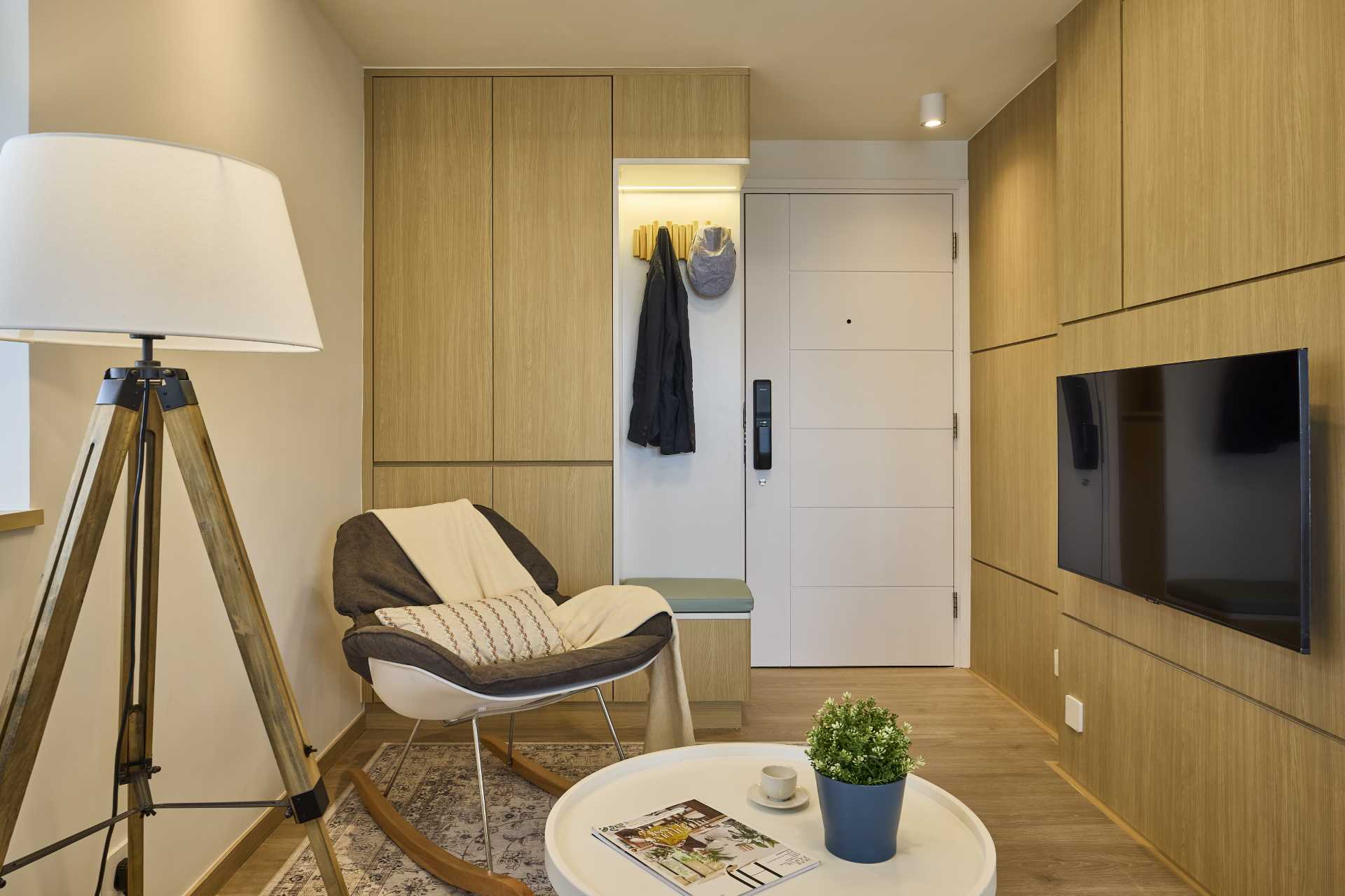 Stepping inside this small apartment, there's an entryway with storage cabinets and a bench with coat hooks above.