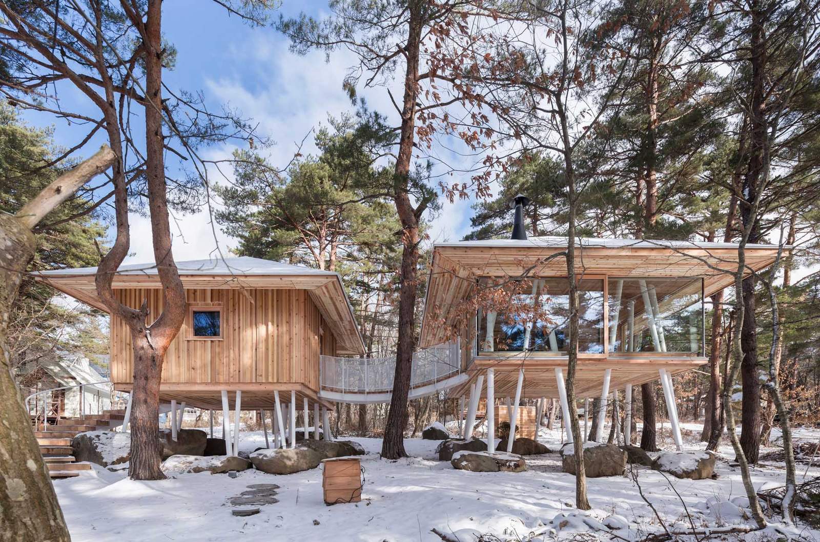 A modern wood house on stilts.