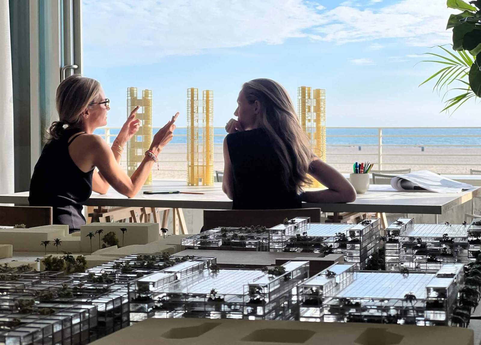 two people face beachfront with model in foreground