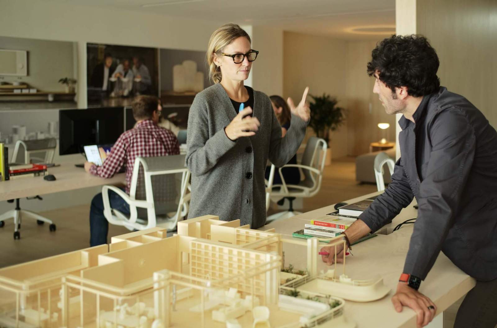 people working around desk with building models