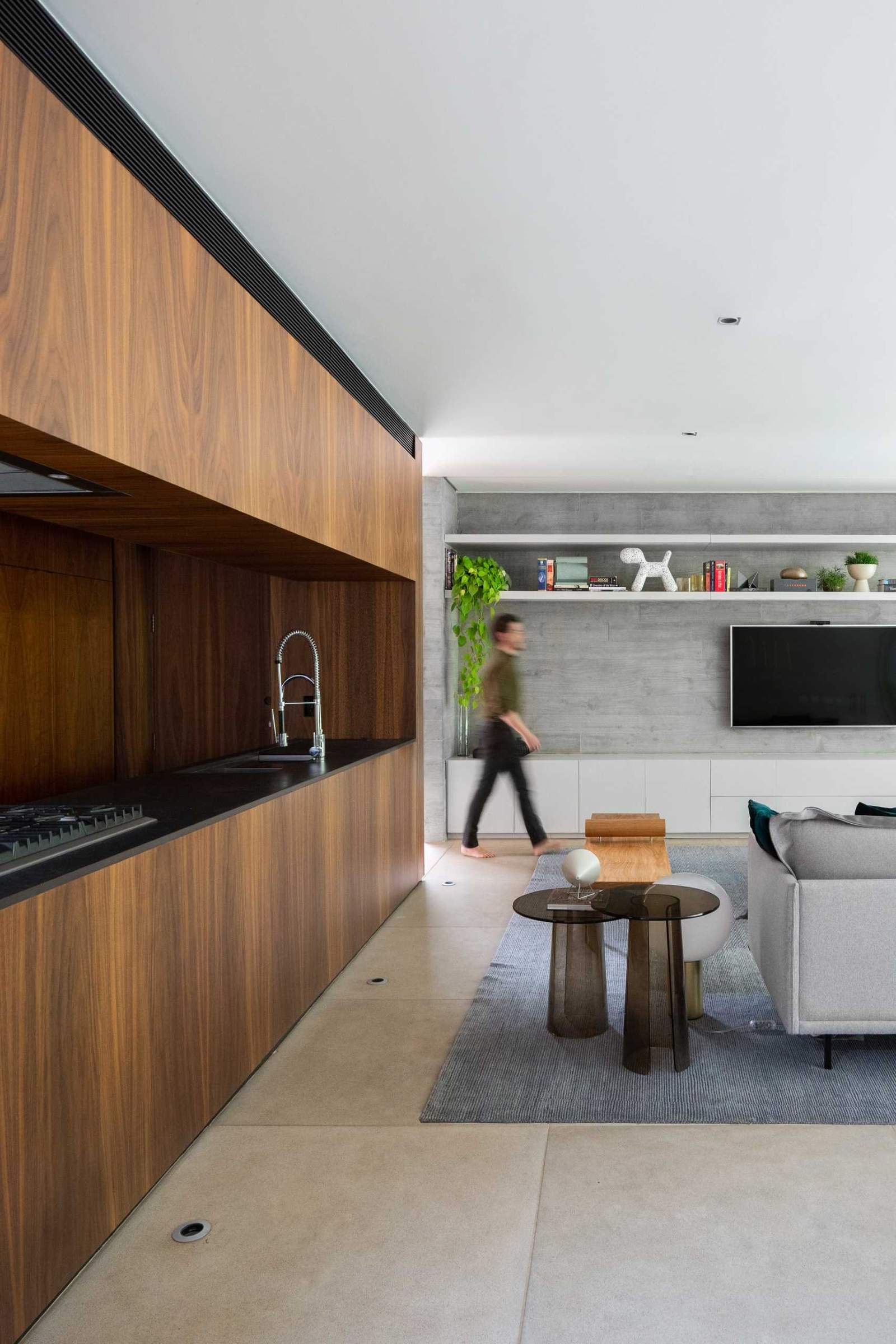 The kitchen, which can be seen through an opening from the living room and dining room, has warm wood cabinetry.