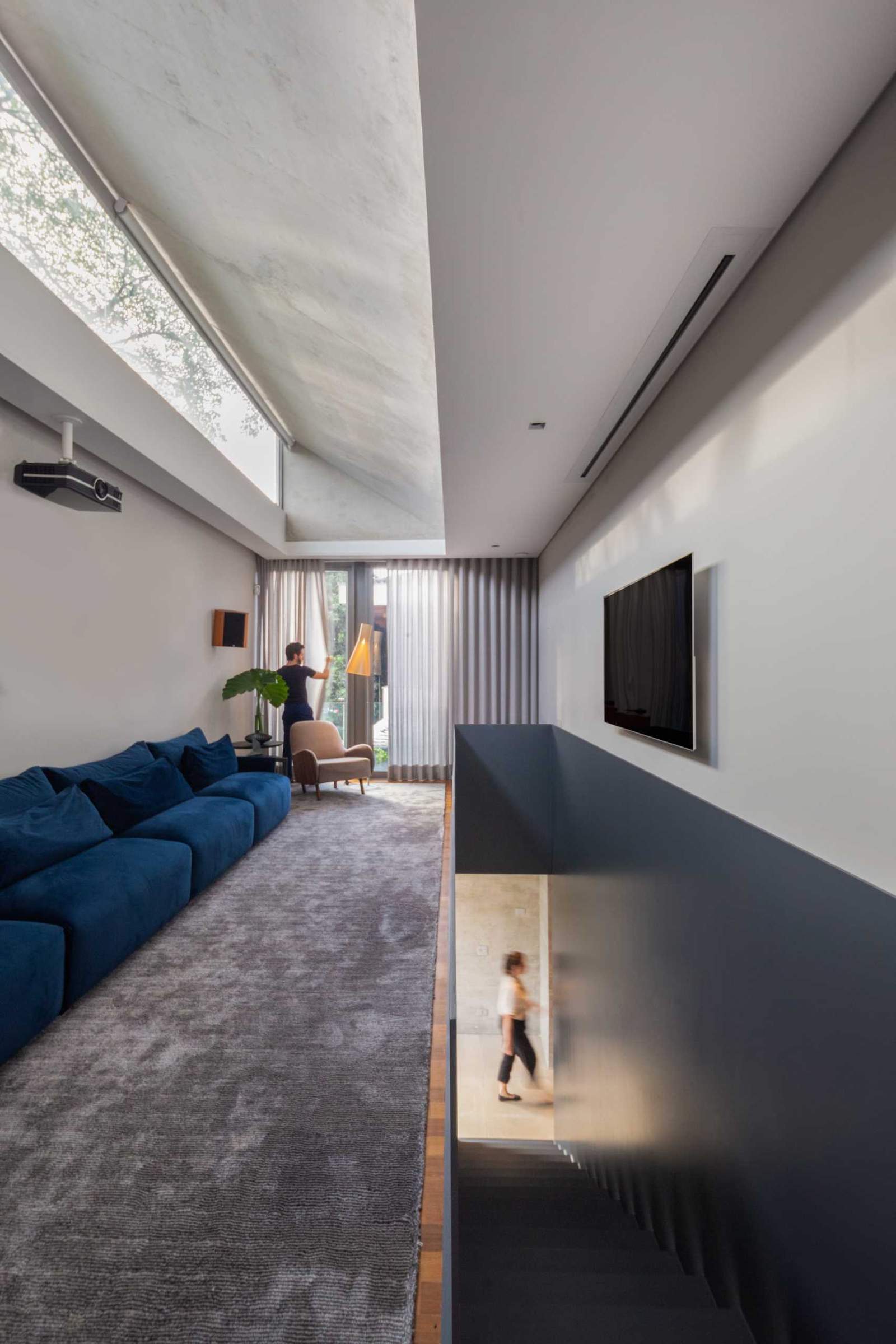 A home theater has been added in a narrow space at the top of the stairs.