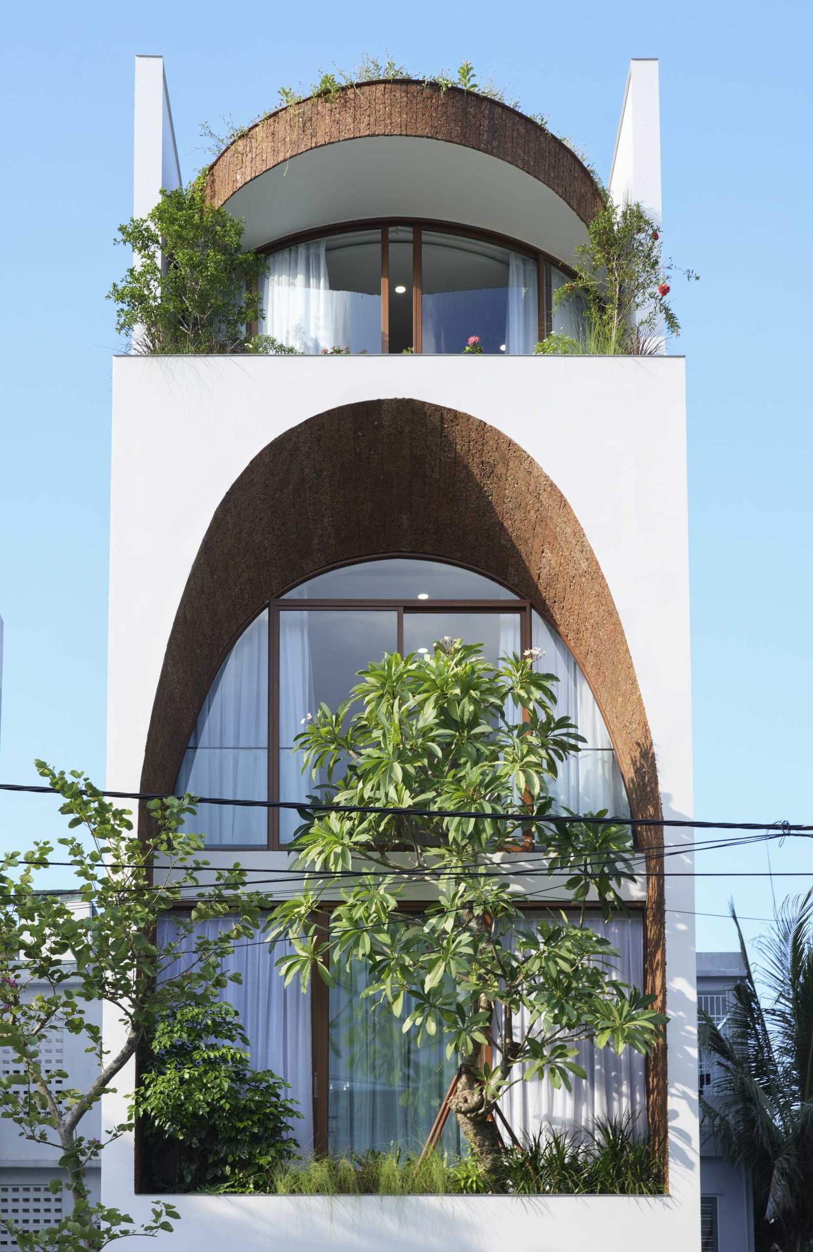 A modern house with a large arch on its facade.