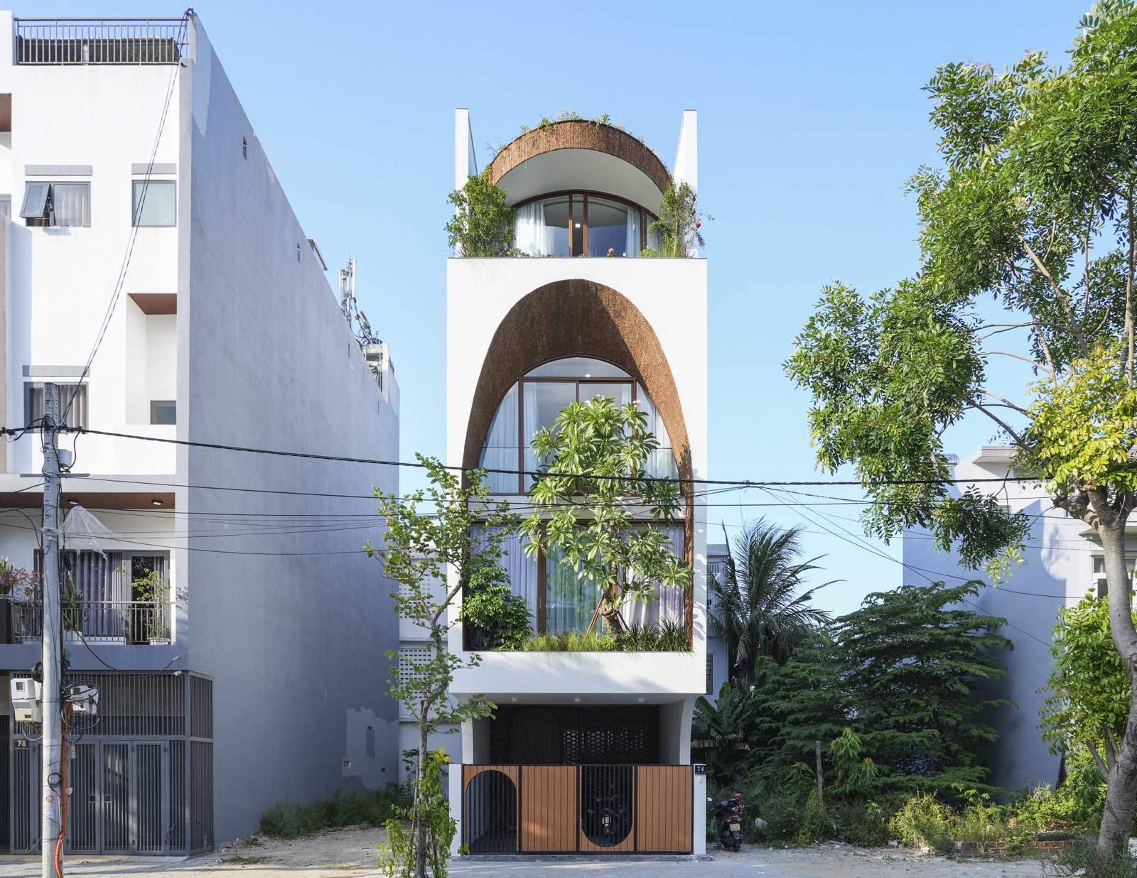 A modern house with a large arch on its facade.