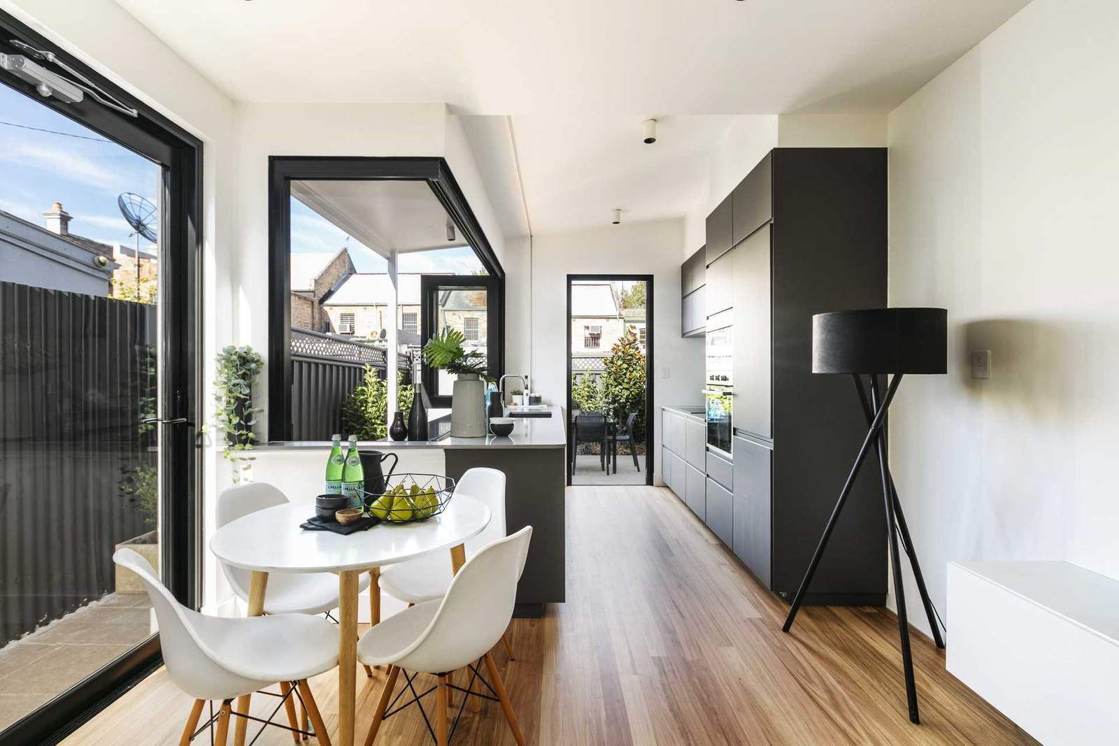 A modern kitchen opens to an outdoor bar area.