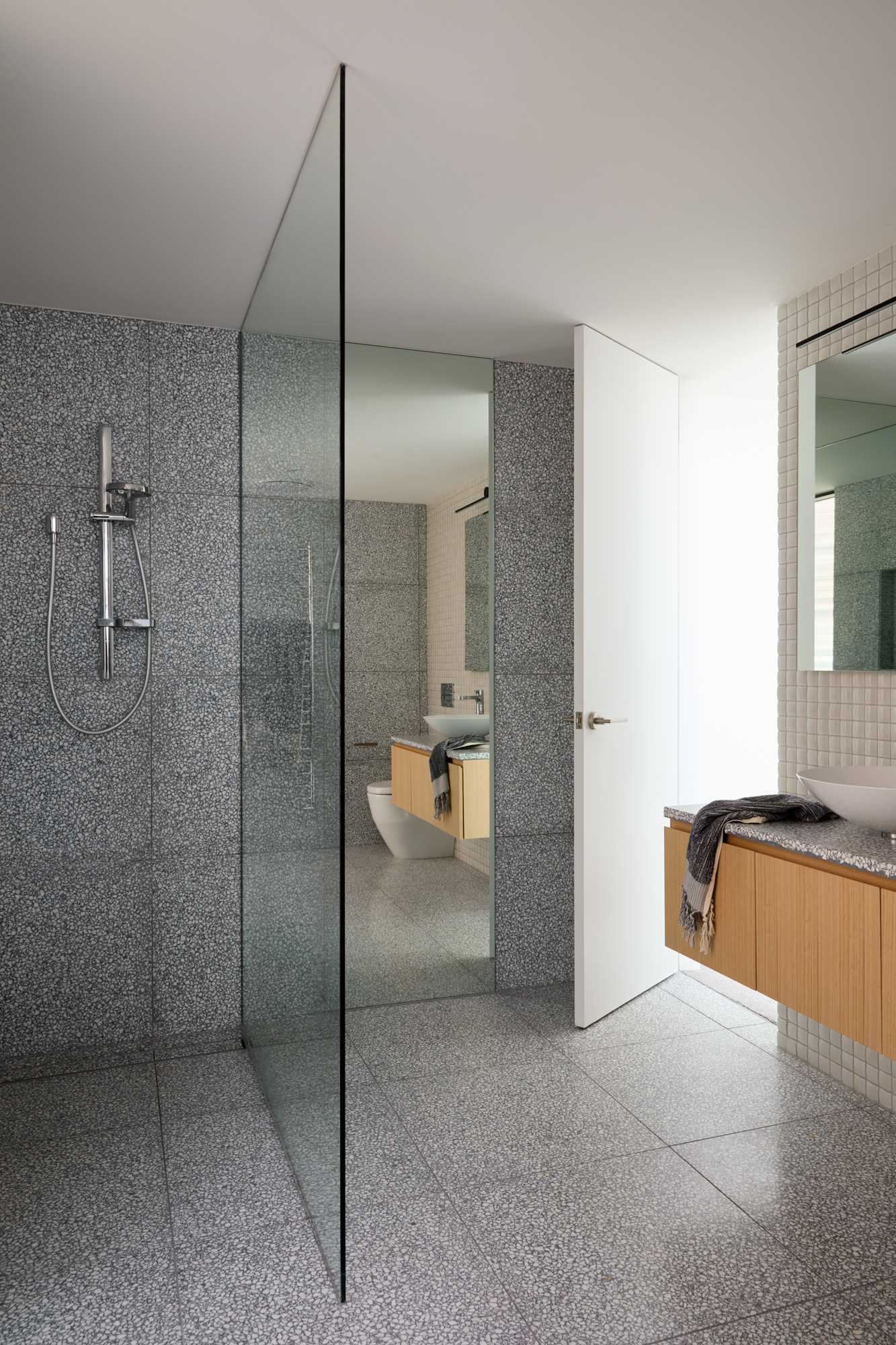 The new en-suite bathroom includes a floating wood vanity, a walk-in shower, and a freestanding bathtub.