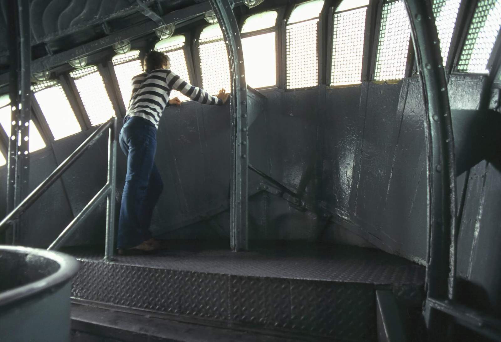 a tourist looks out a window from inside the crown of the statue of liberty