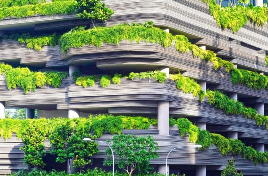 "A modern building covered with lush green plants, showcasing sustainable green architecture."