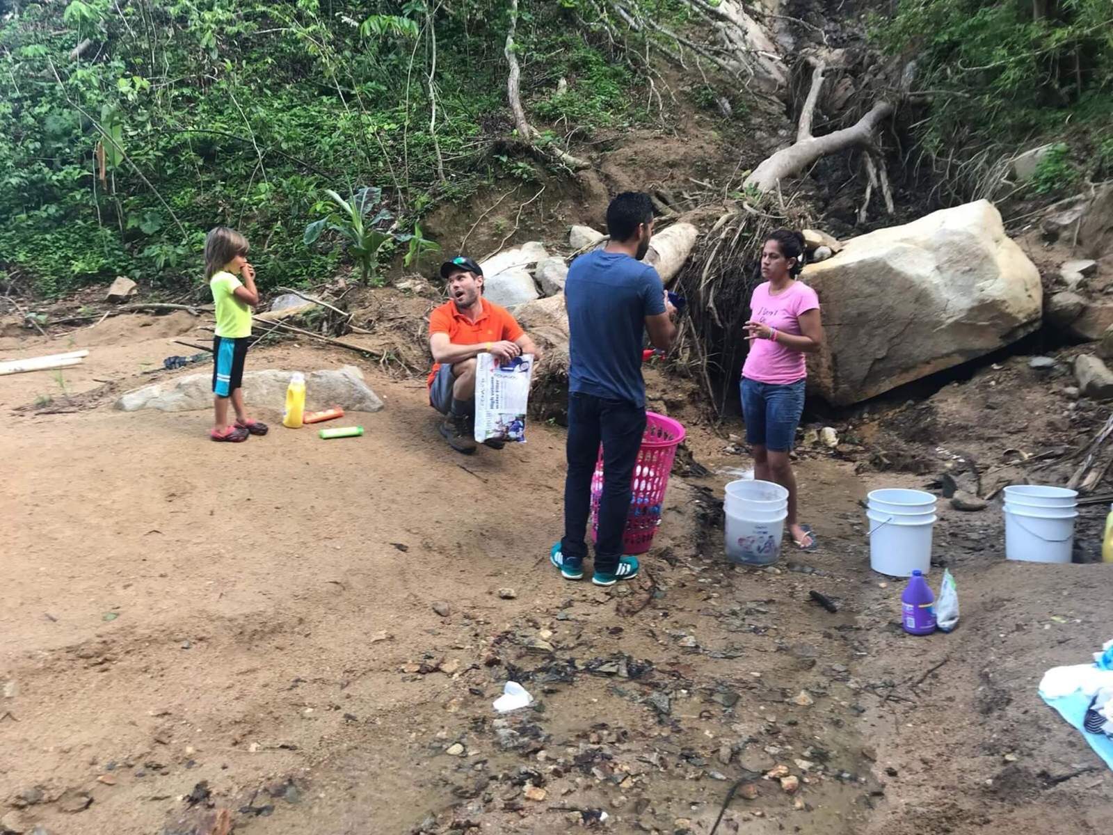 people filling up buckets of water