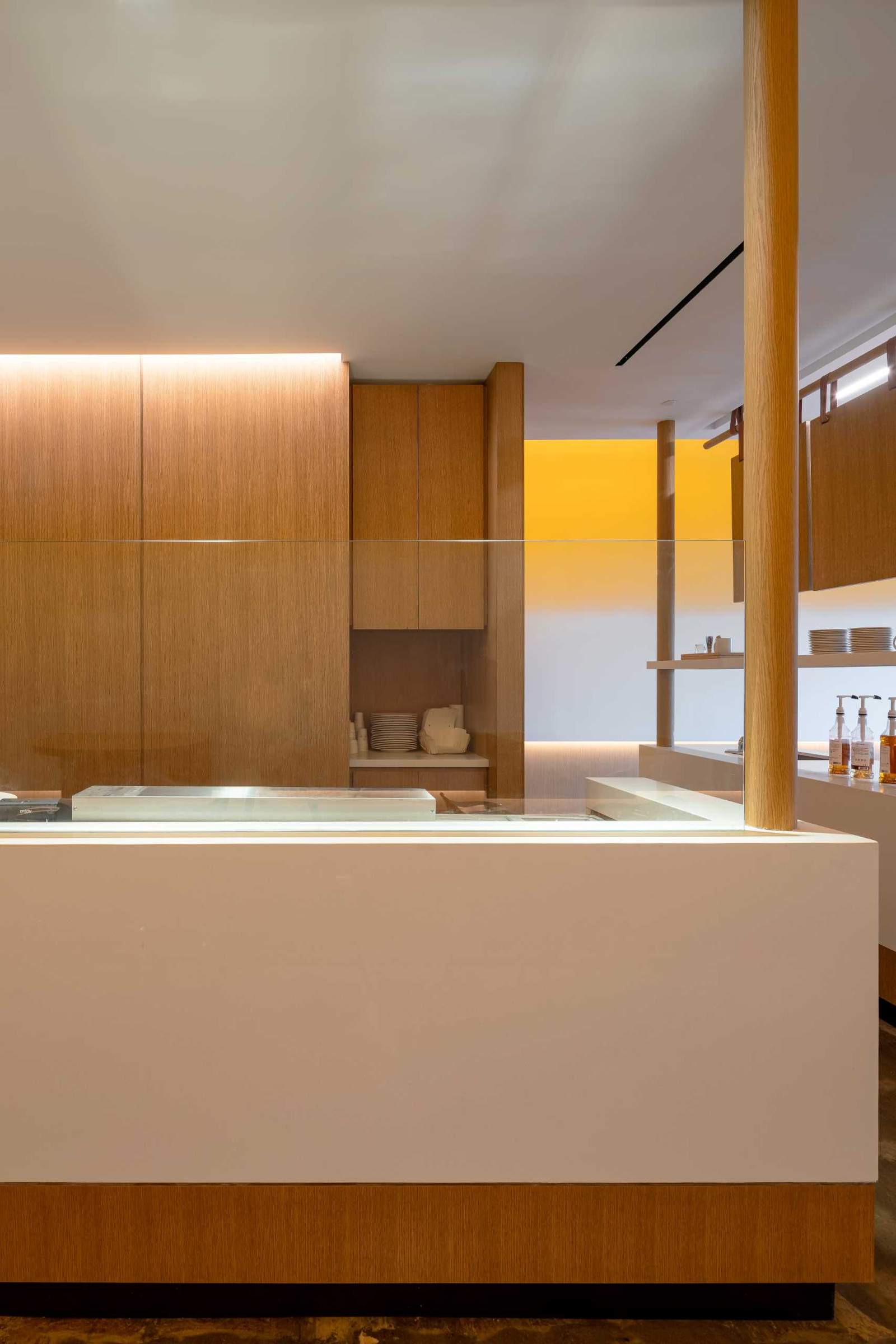 A modern cafe with an exposed kitchen and minimalist serving area.