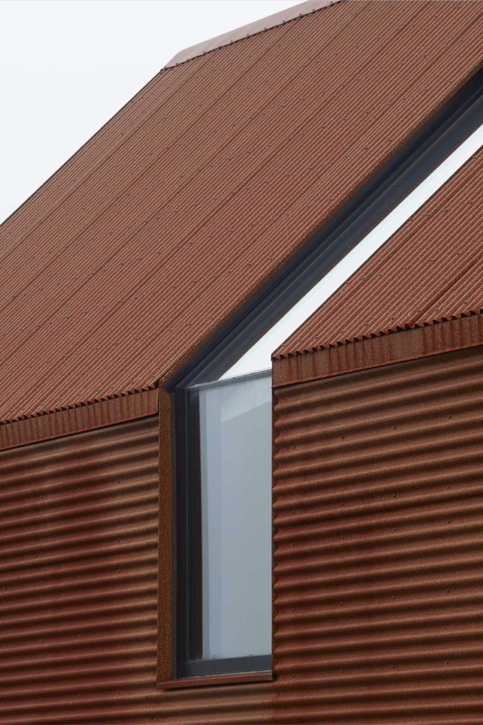 A modern house with weathered corrugated steel exterior.