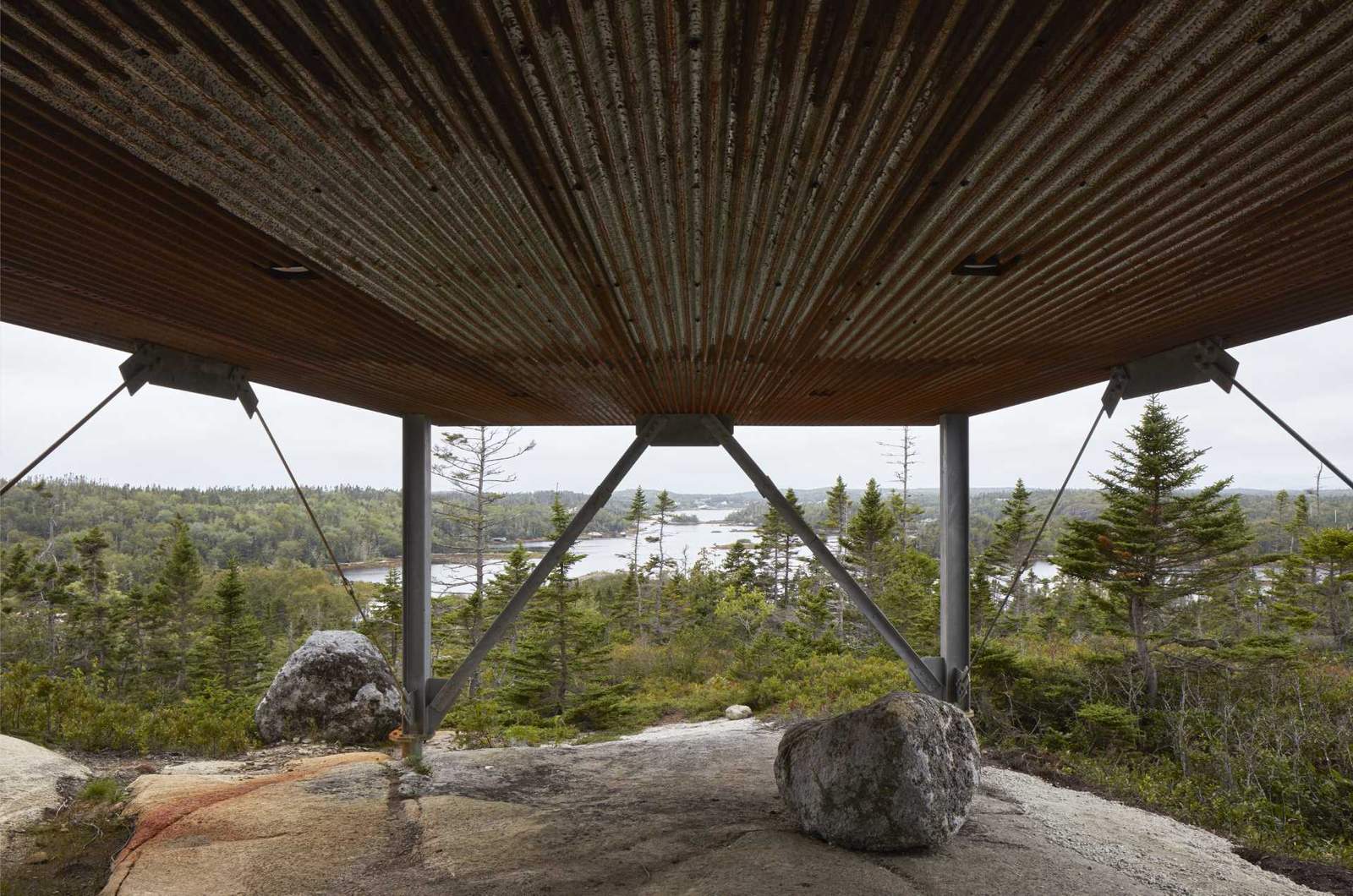 A modern house raised on metal stilts.