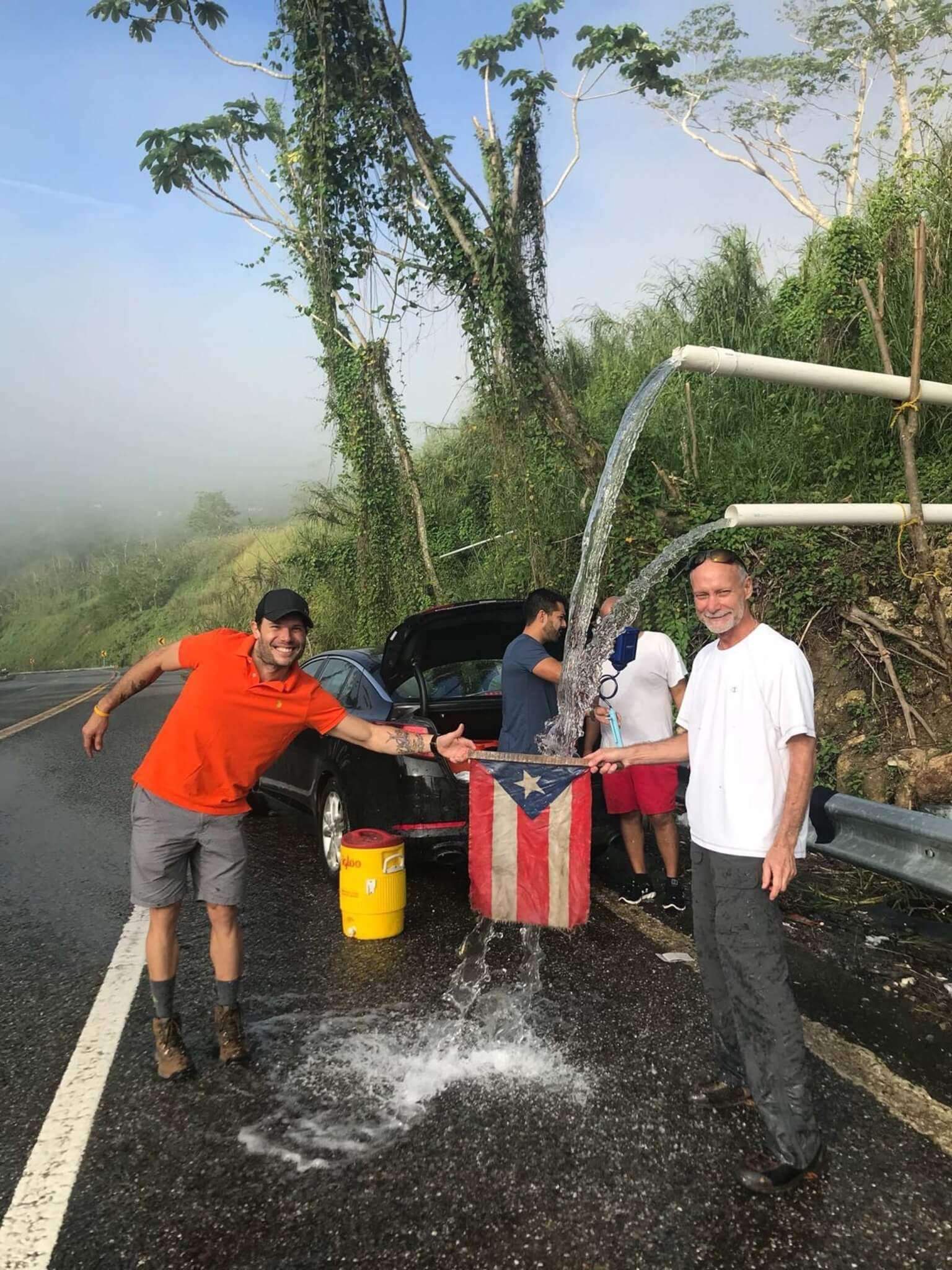 people filling up buckets of water