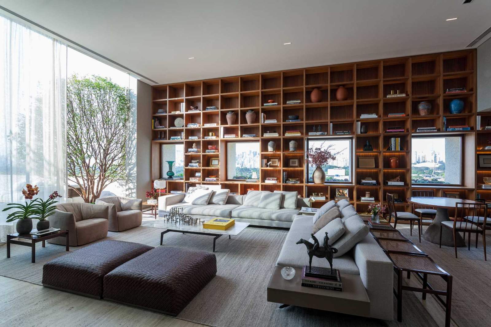 The design of this bookshelf allows the focus to be on the multiple windows that also share the wall, with the shelves framing the windows as if they were paintings.