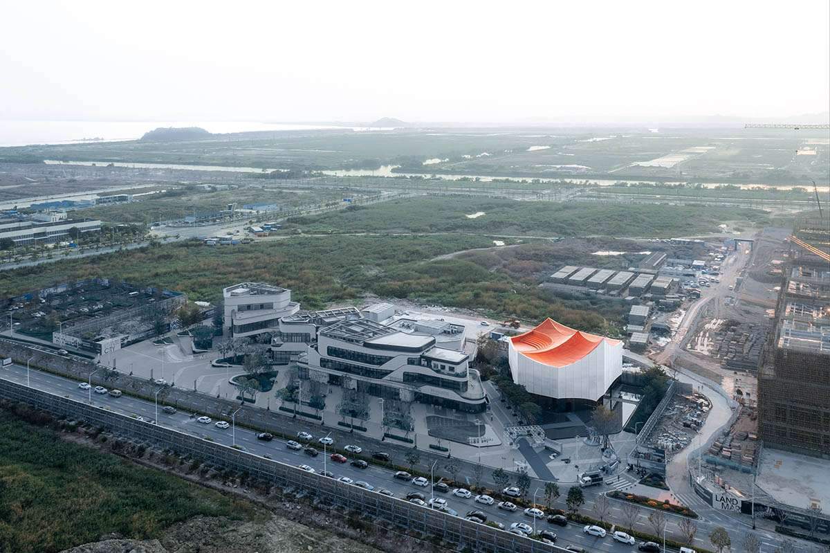 بناء صالة عرض تستحضر الجبال الحمراء الصينية مع سقف برتقالي مبهر