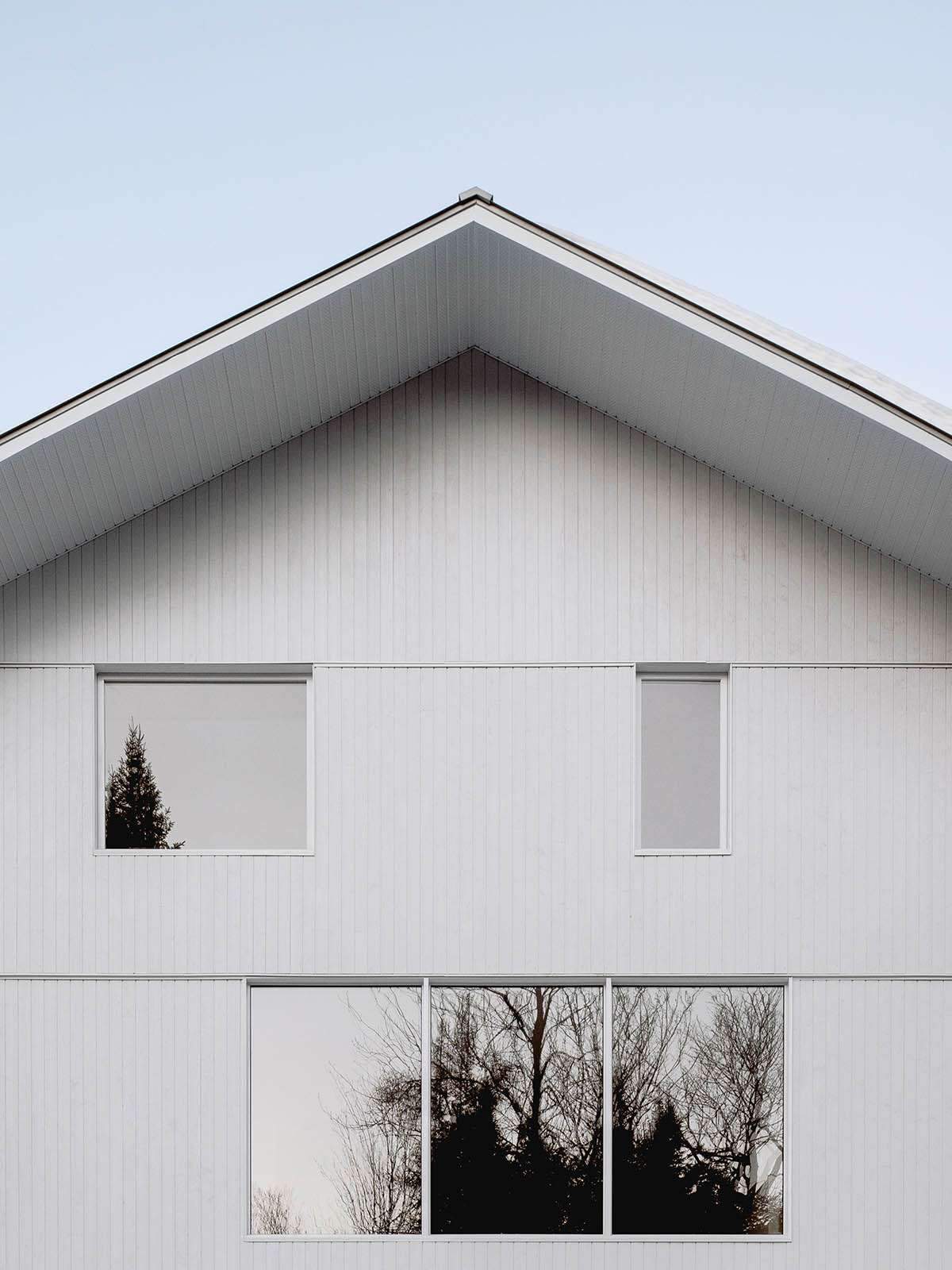 A Canadian winter house looks like it's covered in snow in the woods