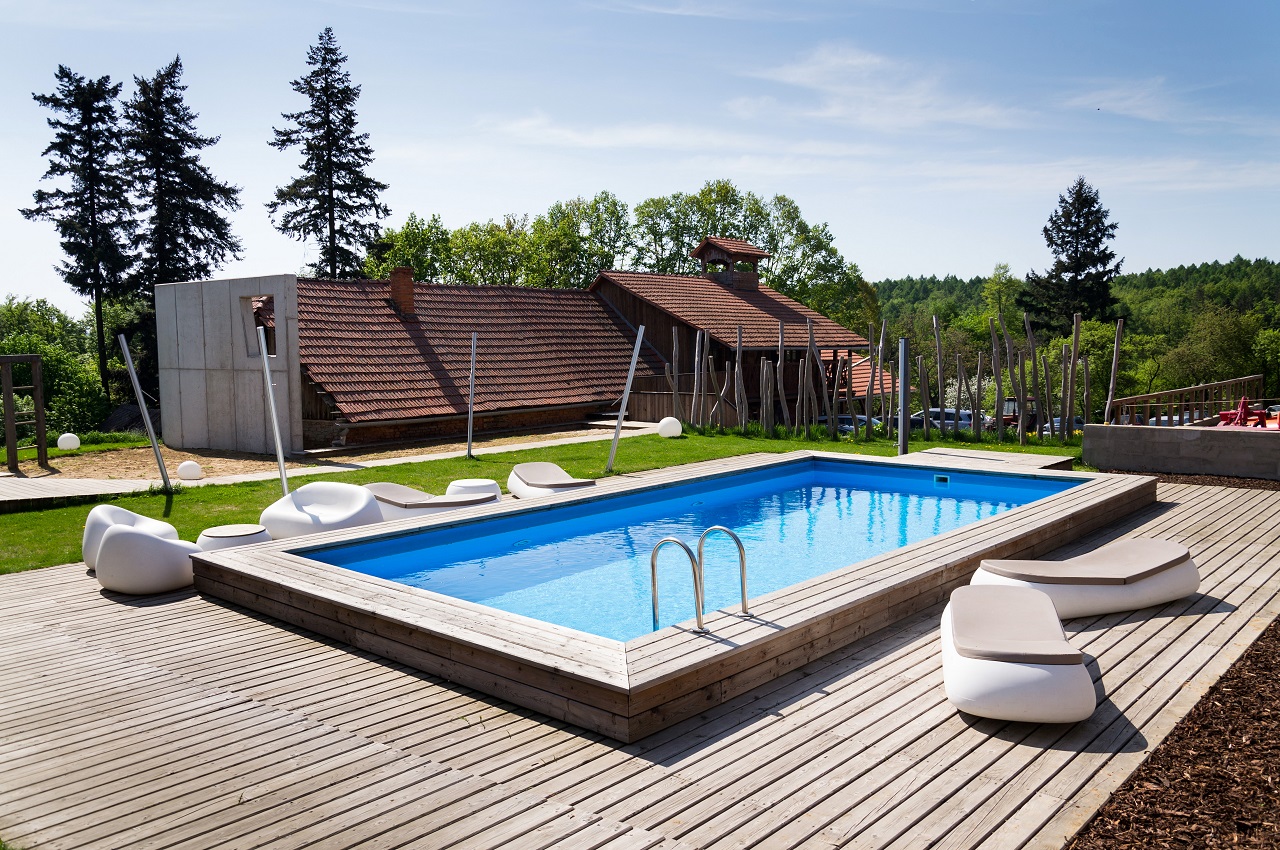 Beautiful outdoor skimmer swimming pool with wooden flooring, steel stairs. Cocktail pool.