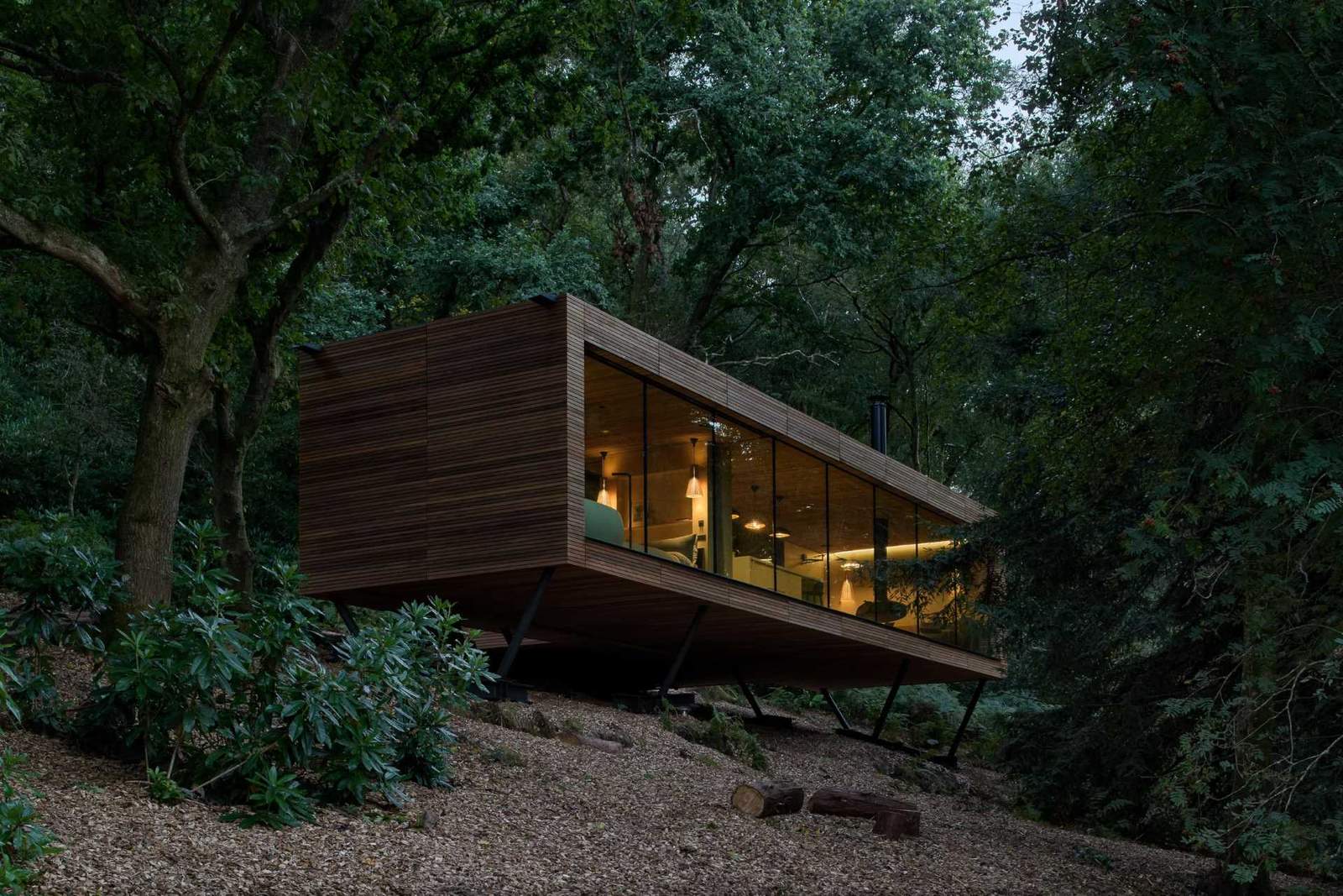 A wood clad home nestled between the trees.