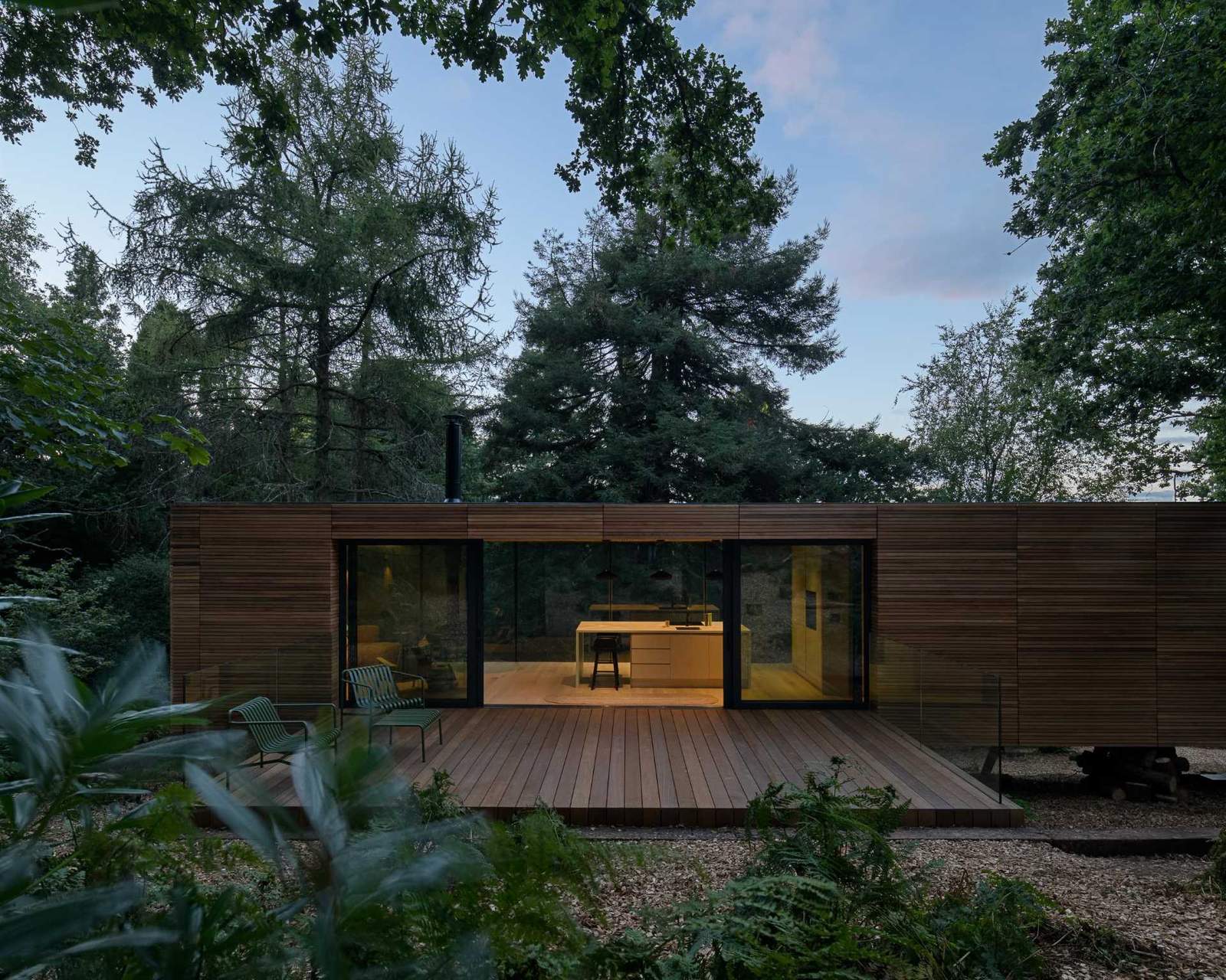 A wood clad home nestled between the trees.