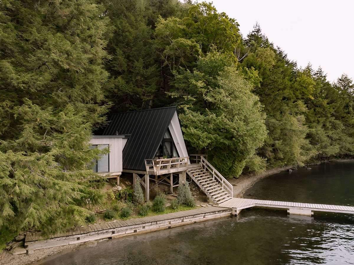 تصميم منزل ريفي صغير على شكل حرف A يعزز الشعور بالاسترخاء المطل على البحيرة