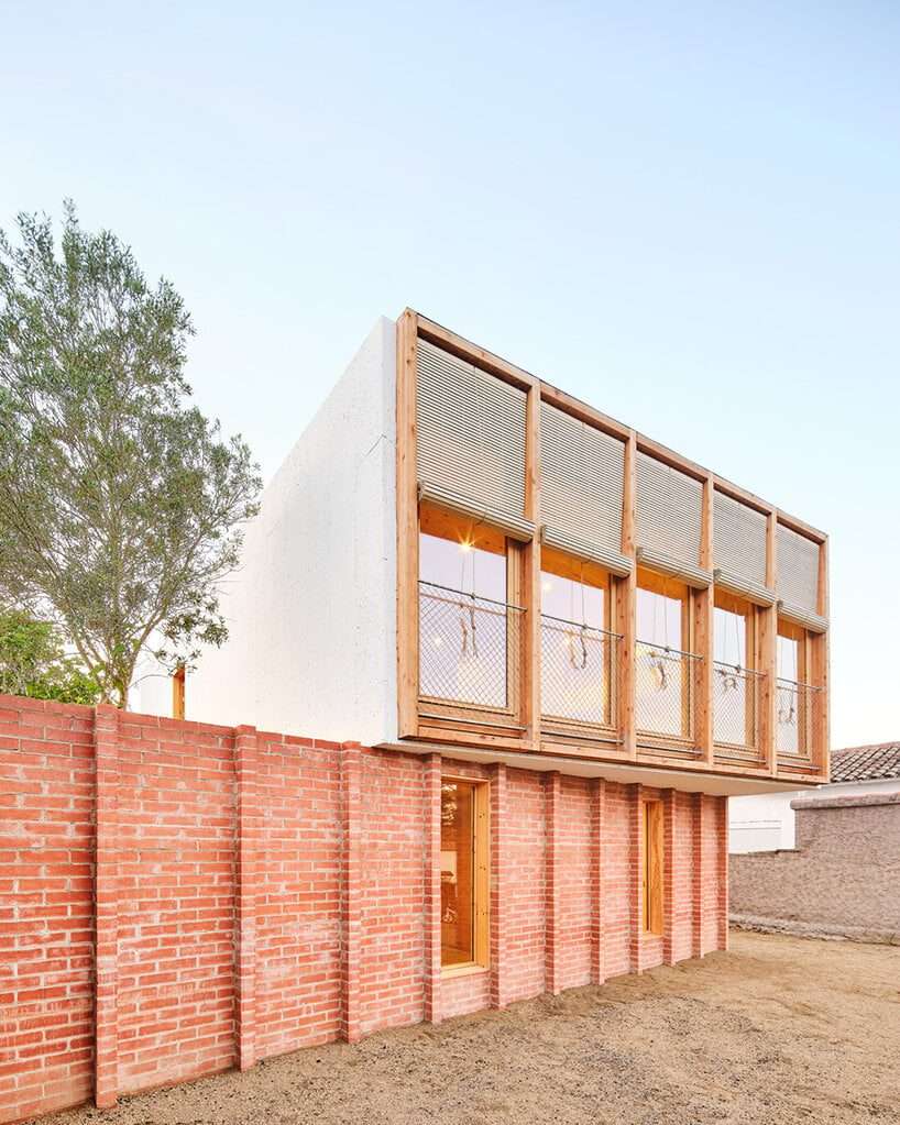 أكوام ágora arquitectura عبر منزل خشبي مصفح فوق قاعدة من الطوب القديم في إسبانيا
