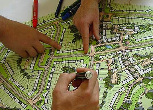 A team of engineers reviewing a sustainable urban planning map using colored markers to enhance the environmental design of the city.