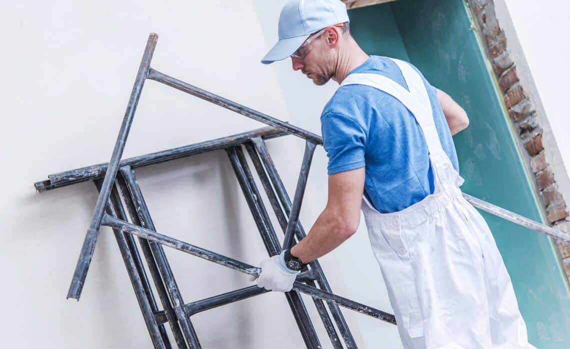 6 Best Scaffolding Systems For Home Use Of 2023 1 Caucasian construction worker preparing scaffolding inside remodeling house.