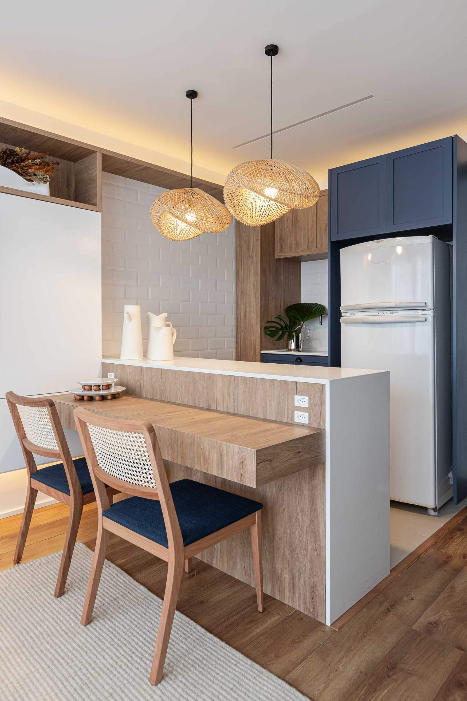 This small kitchen has a peninsula with a counter for seating, which also acts as a dining area or a desk.