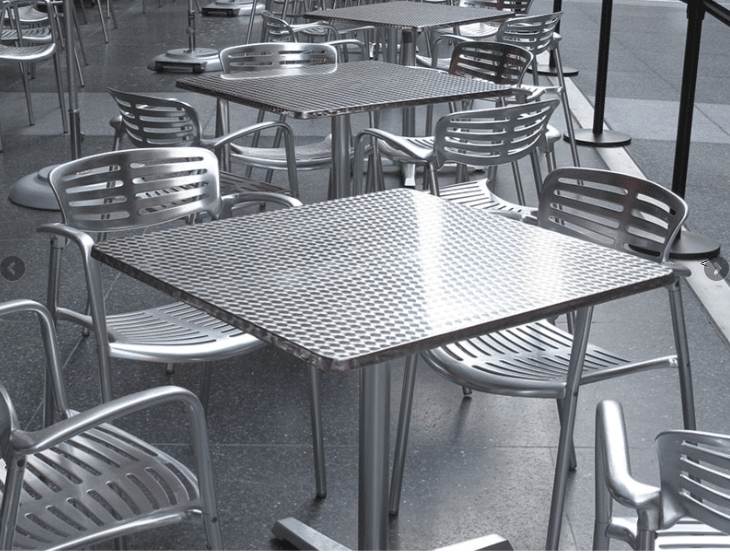 Metal chairs and tables in a seating area featuring metals in furniture