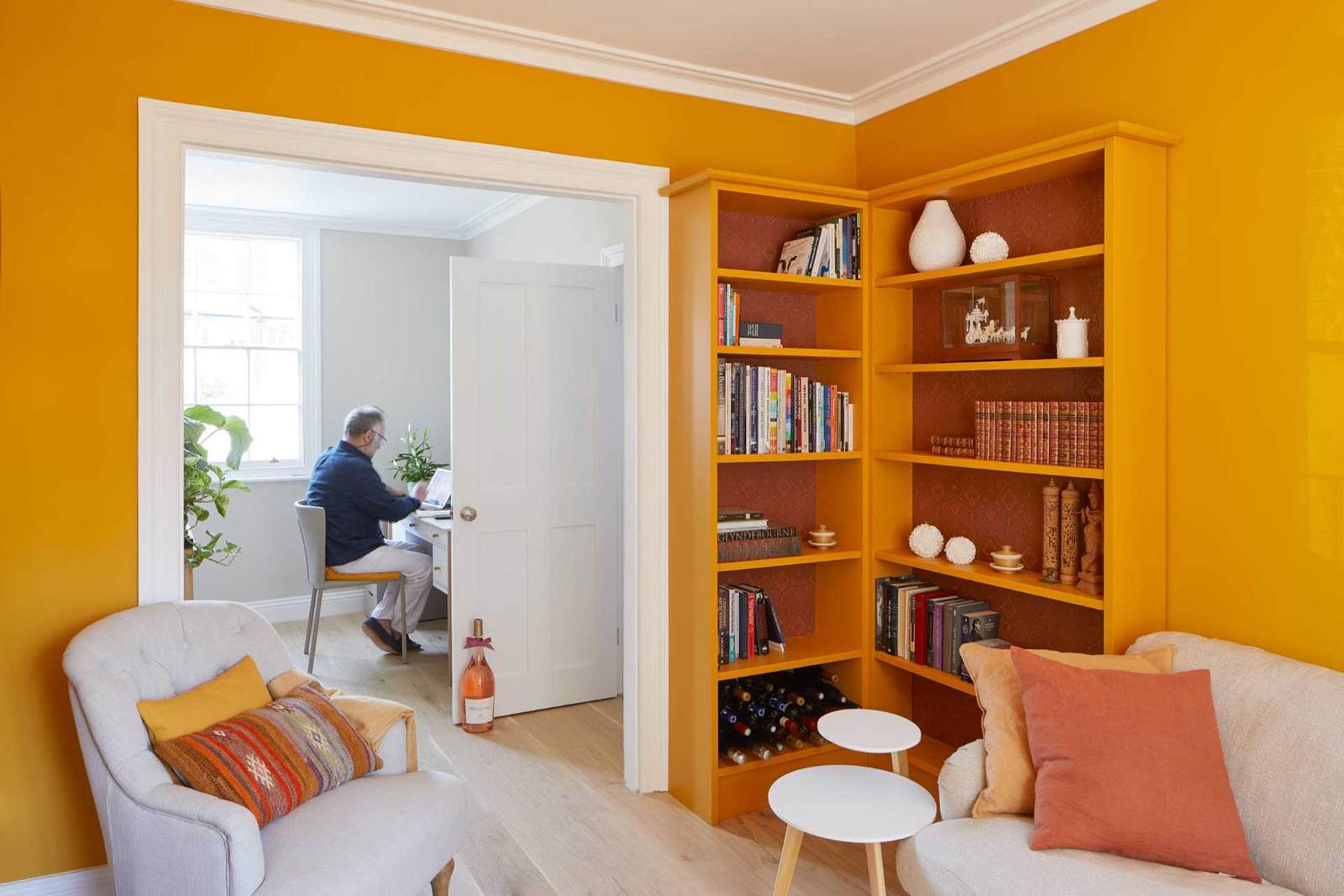 Orange was the color of choice for a sitting room, with a pair of bookshelves that match the wall. 