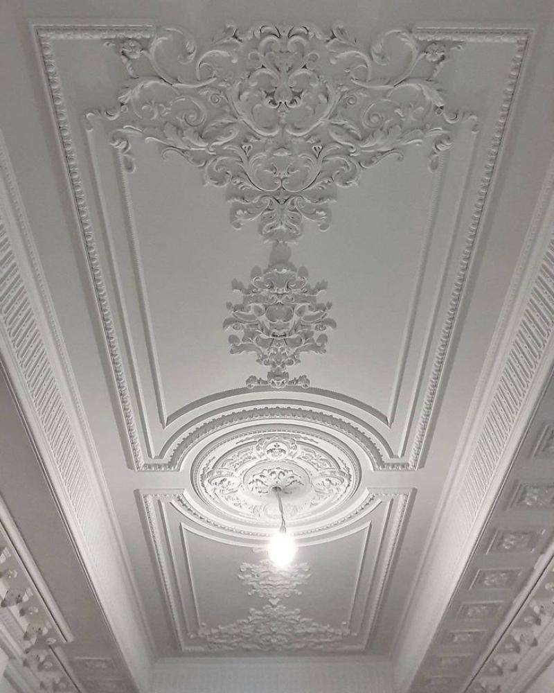 "Decorative ceiling with intricate stucco designs, adding a classic and elegant touch."