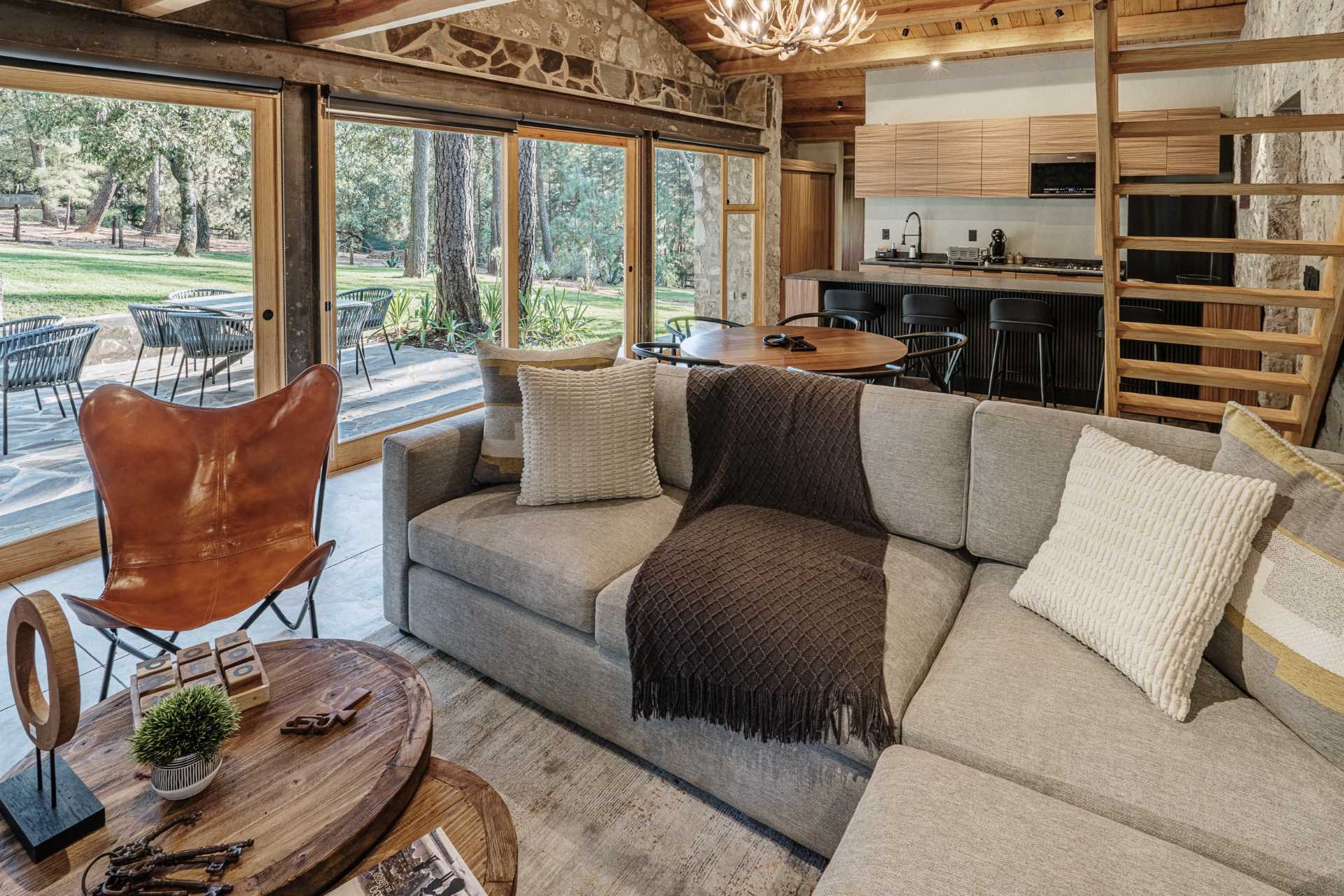 منزل حجري معاصر مع غرفة معيشة ذات مخطط مفتوح ومنطقة لتناول الطعام ومطبخ.  هناك أيضًا غرفة نوم في الطابق العلوي.