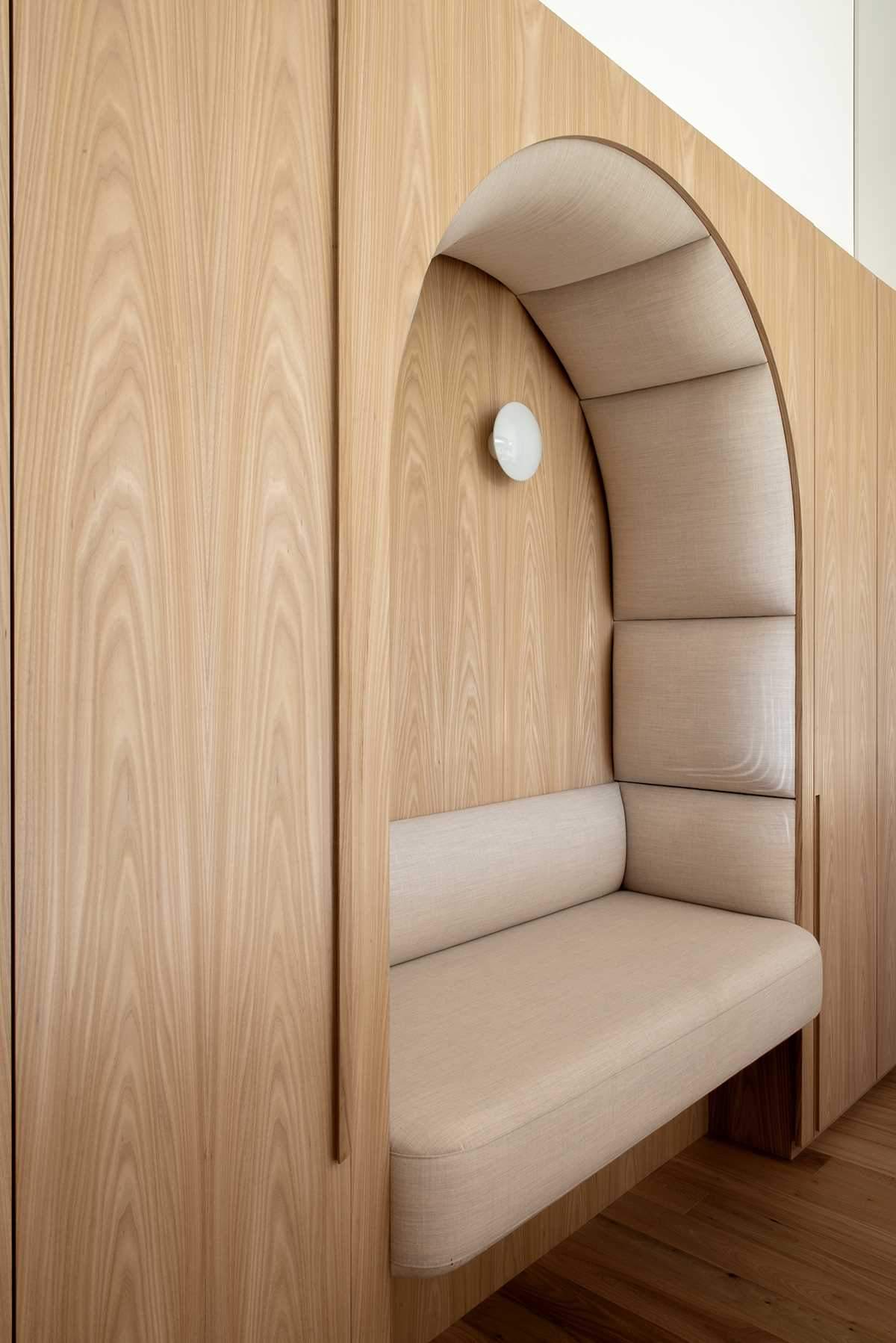 A wall of cabinetry includes a padded built-in bench.