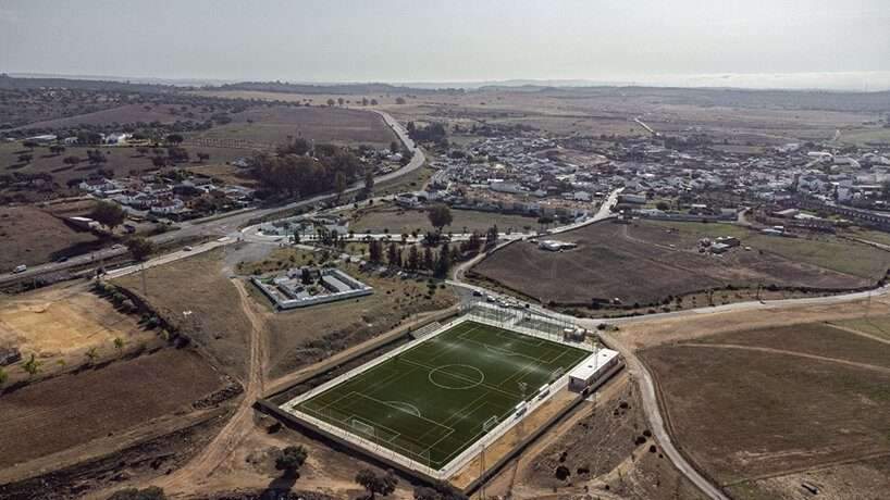 elongated brick-clad changing room completes small football field in seville