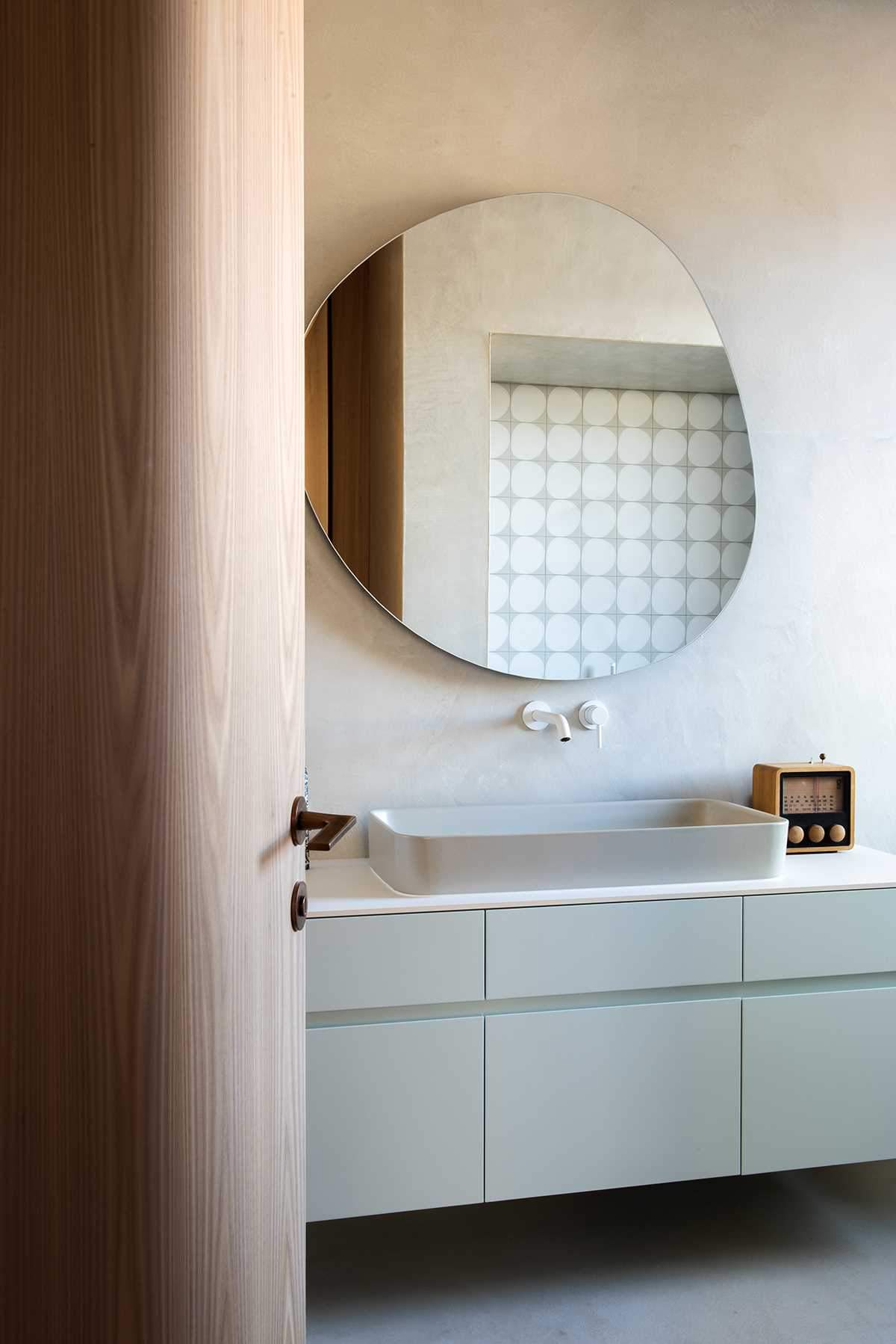 This modern bathroom has a soft minty green vanity.